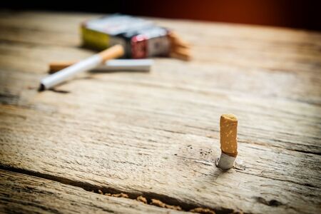 Tobacco in the cigarette, lying on a wooden tableの写真素材