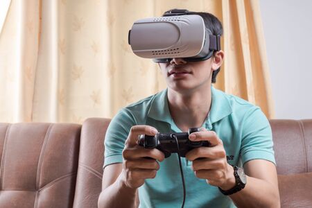 Man wearing virtual reality goggles watching movies or playing video games.の写真素材