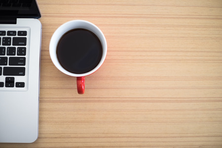 Top view desk work laptop and coffee cup notepad in home officeの写真素材