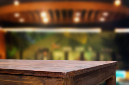Selected focus empty brown wooden table and Coffee shop restaurant blur background with bokeh image....
