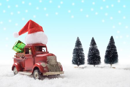 Christmas toy santa  truck with gift boxes and pine tree on snow background.の写真素材