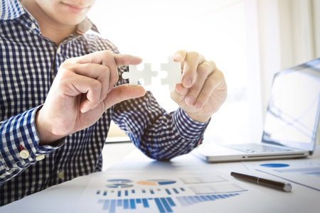 business people assembling holding two blank jigsaw puzzle  pieces in his hands conceptual of...