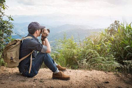 Young professional travrler man with camera shooting outdoor, fantastic mountain landscape.の写真素材