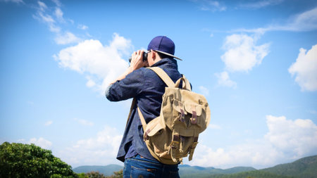 Man Binoculars Looking Mountain Cloudscape Traveling Concept.の写真素材
