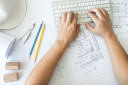 Architect or engineer working on keyboard blueprint and architecture mode in office room, Construction conceptの写真素材