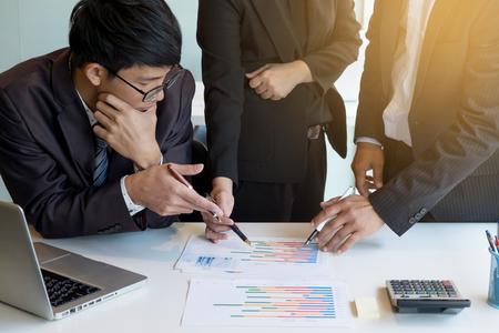 Teamwork process. young business managers crew working with new startup project. labtop on office wood table, typing keyboard, texting message, analyze graph plansの写真素材