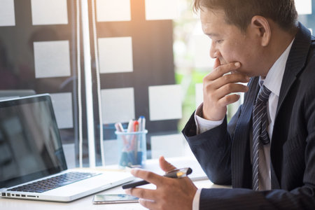 Working process startup. Businessman working at the wood table with new finance project. Modern notebook on table. Pen holding handの写真素材