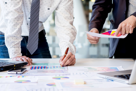 Teamwork process. young business managers crew working with new startup project. labtop on office wood table, typing keyboard, texting message, analyze graph plansの写真素材
