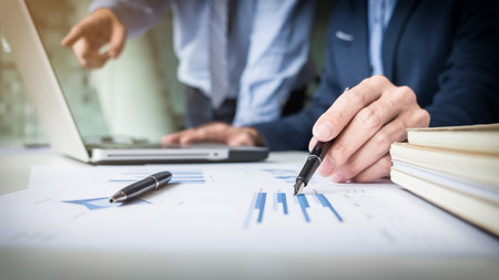 Team work process. young business managers crew working with new startup project. labtop on wood table, typing keyboard, texting message, analyze graph plans.の写真素材