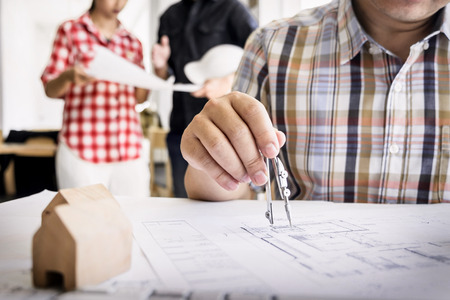 Close-up Of Person's Hand Drawing Plan On Blue Print with architect equipmentの写真素材