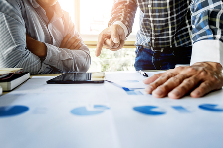 Team work process. young business managers crew working with new startup project. labtop on wood table, typing keyboard, texting message, analyse graph plans.の写真素材