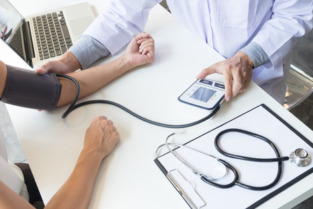 healthcare, hospital and medicine concept - doctor and patient measuring blood pressure.の写真素材