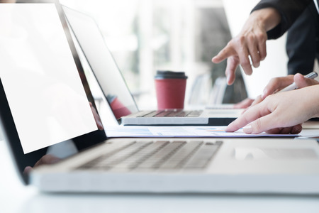Team work process. young business managers crew working with new startup project. labtop on wood table, typing keyboard, texting message, analyse graph plans.の写真素材