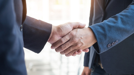 Two confident business man shaking hands during a meeting in the office, success, dealing, greeting and partner conceptの写真素材