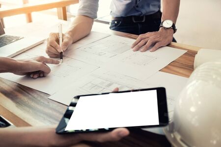Two Architects engineer discussing  data working and tablet, laptop with blueprint - Closeup on hands and project print.の写真素材