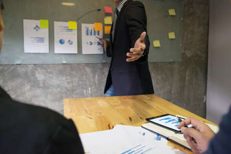 Business man speaker giving a talk finance profit graph presentation meeting audience in the conference modern office at board brainstorming meeting working concept.の写真素材