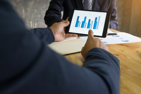 business man financial inspector and secretary making report, calculating or checking balance. Internal Revenue Service inspector checking document. Audit concept at working with plan on office desk and modern digital tabletの写真素材