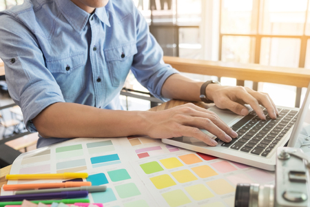 Hands of female hipster modern graphic designer in office working with colour samples. Woman at workplace choosing colourful swatches, close-up. Creative people concept.の写真素材