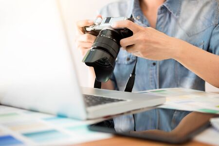 Photography Ideas Creative Occupation Design Studio Concept, Female photographer sitting on the desk with laptop.の写真素材