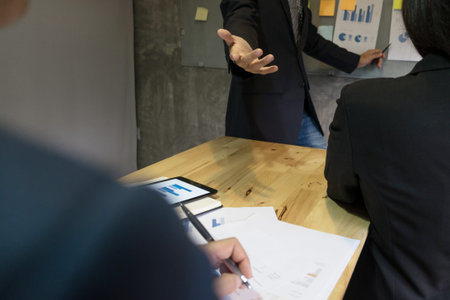Business man speaker giving a talk finance profit graph presentation meeting audience in the conference modern office at board brainstorming meeting working concept.の写真素材