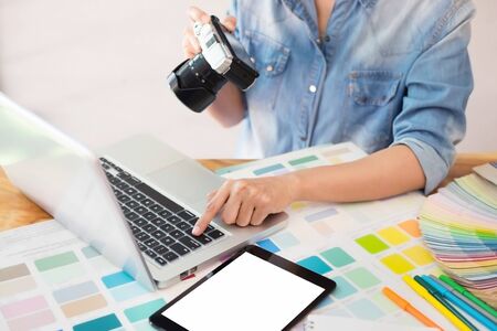 Photography Ideas Creative Occupation Design Studio Concept, Female photographer sitting on the desk with laptop.の写真素材