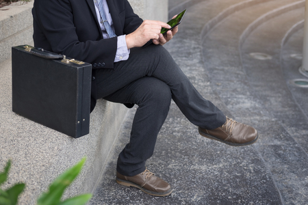 Young successful businessman using tablet for working in park outdoors.の写真素材