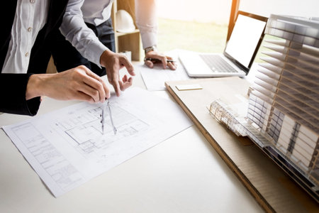Person's engineer Hand Drawing Plan On Blue Print with architect equipment.