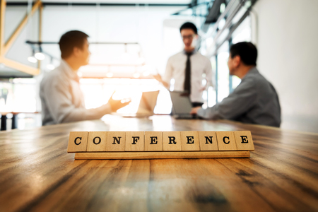 Conference word on wood table with Business team work discussion together concept in backgroundの写真素材