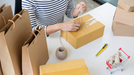 Business owner woman working online shopping prepare product packaging process at her home, young...