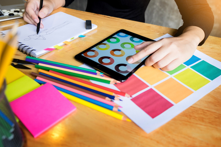 women working as fashion designer choosing on colour chart for clothes in digital tablet at workplace studioの写真素材