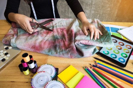 Hands notch tailor tailor's scissors cloth cutting a piece of fabric (fashion designer concept)の写真素材