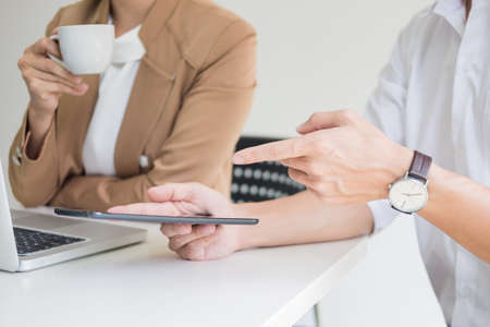 Team work process. young business managers crew working with new startup project. labtop on wood table, typing keyboard, texting message, analyze graph plansの写真素材