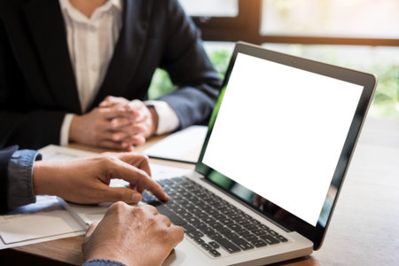 Businessman team working at office desk and using a digital computer laptop hands detail, computer and objects on the tableの写真素材