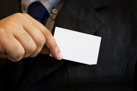 business man showing business card. Black suit and tieの写真素材