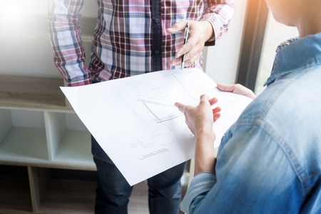 Architects engineer discussing at the table with blueprint - Closeup on hands and project print.の写真素材