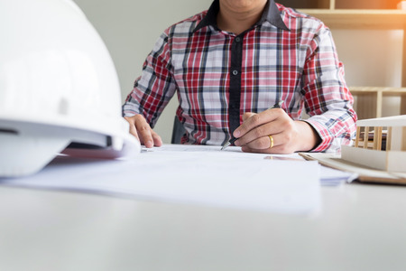 Person's engineer Hand Drawing Plan On Blue Print or working project in his office with architect equipmentの写真素材