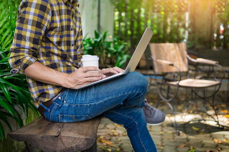 man on week-end working on laptop computer outdoor in a park garden during a sunny summer dayの写真素材