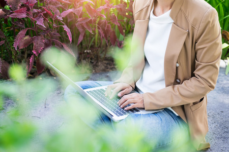 business woman hand using laptop on table in gardenの写真素材