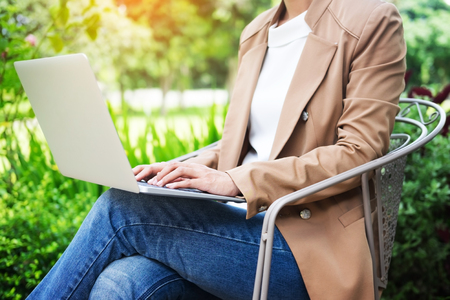 business woman hand using laptop on table in gardenの写真素材