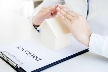 Female hands saving small house, Real estate business. insurance protection concept.の写真素材