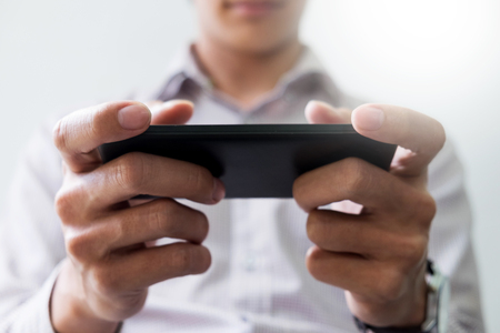 Closeup of Teenager Playing videogames On Mobile phoneの写真素材
