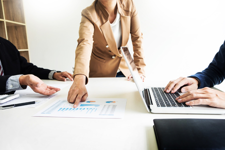 Team work process. young business managers crew working with new startup project. labtop on wood table, typing keyboard, texting message, analyze graph plansの写真素材