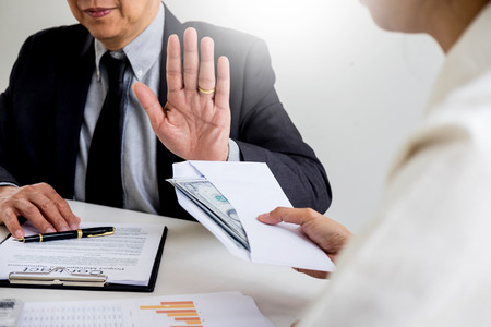 Businessman refusing or rejecting money in the envelope - anti bribery and corruption conceptsの写真素材