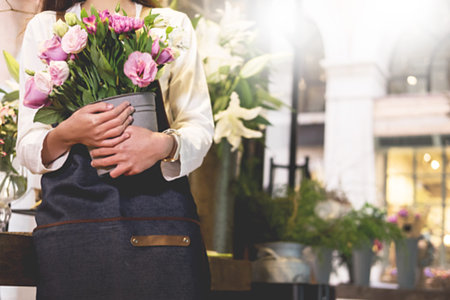 young women business owner florist making bouquet  in front of flower shopの写真素材