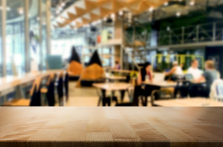 Selected focus empty brown wooden table and Coffee shop or restaurant blur background with bokeh...