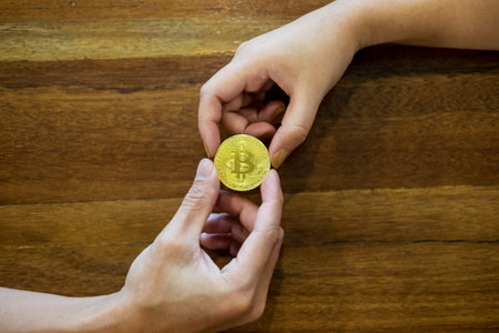 hand exchange golden metal Bitcoin crypto currency investment- symbolic block chain financial...