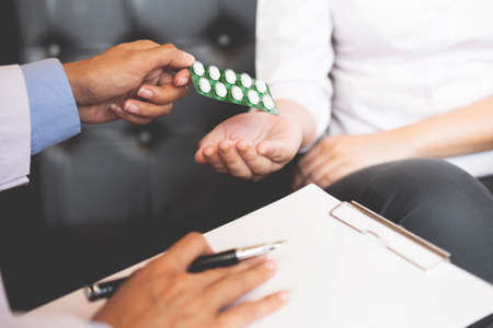 doctor hand holding tablet of drug and explain to patient in hospital room.の写真素材