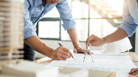 Close-up Of Person's engineer Hand Drawing Plan On Blue Print with architect equipment, Architects discussing at the table, team work and work flow construction concept.の写真素材