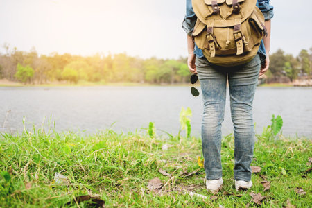 Confident woman posing on the shore of a wild lake, with mountains on the background, amazing tourist attractions.の写真素材