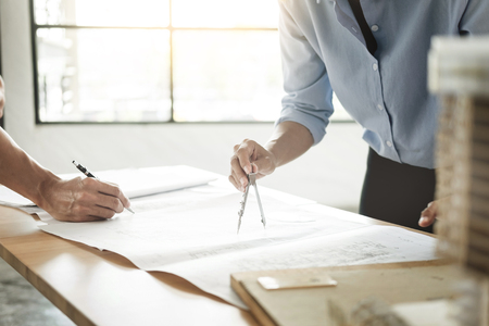 Close-up Of Person's engineer Hand Drawing Plan On Blue Print with architect equipment, Architects discussing at the table, team work and work flow construction concept.の写真素材